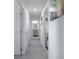 Hallway with gray carpet leads to a bathroom with gray vanity and white fixtures; laundry is to the right at 5189 Greenheart Ave, Mount Dora, FL 32757