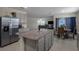 Open-concept kitchen featuring granite counters, a stainless steel refrigerator, and views of the living room at 5189 Greenheart Ave, Mount Dora, FL 32757