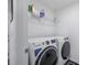 Laundry room with GE washer and dryer for convenient laundry at 5189 Greenheart Ave, Mount Dora, FL 32757
