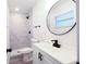 Bright bathroom with modern fixtures, a round mirror, and a tiled walk-in shower at 808 S Clara Ave, Deland, FL 32720