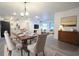Open concept dining area with table set for six, with views into living room and kitchen at 808 S Clara Ave, Deland, FL 32720