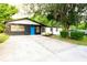 Charming home with stone accents, a vibrant blue door, and mature trees creating a welcoming entrance at 808 S Clara Ave, Deland, FL 32720