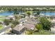 An aerial view of homes within a community that feature rooftops, green spaces, and a nearby pond at 1309 Timberbend Cir, Orlando, FL 32824