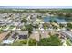 An aerial view of homes within a community that feature rooftops, green spaces, and a nearby pond at 1309 Timberbend Cir, Orlando, FL 32824