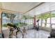 Enclosed sun room with tile flooring featuring a bike, exercise bike, and view of fenced backyard at 1309 Timberbend Cir, Orlando, FL 32824