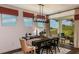 Bright dining room with modern light fixture, dining table, chairs, rug, and view to backyard at 17020 Cercis Loop, Clermont, FL 34711