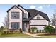 Charming two-story home boasts a modern farmhouse design and well-manicured lawn with sidewalk leading to front door at 17020 Cercis Loop, Clermont, FL 34711