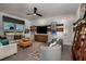 Stylish living room features modern decor, a ceiling fan, and large windows with outdoor views at 17020 Cercis Loop, Clermont, FL 34711