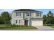 Two story home showcasing a front-facing two car garage and charming red front door at 2180 Albatross Nest Dr, Bartow, FL 33830