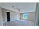 Bedroom with neutral colored walls, carpeted floors, ceiling fan, and a window overlooking the front yard at 4300 Meadow Ridge Ave, Mulberry, FL 33860