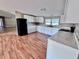 A great kitchen featuring white cabinetry and modern appliances with adjacent living area and new vinyl floors at 4300 Meadow Ridge Ave, Mulberry, FL 33860