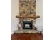 Stone fireplace with a wooden mantle and a stone hearth is ready for relaxation at 6726 Nw 54Th Loop, Ocala, FL 34482