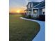 Beautiful home with a manicured lawn, landscaping, and a view of the sunset at 6726 Nw 54Th Loop, Ocala, FL 34482