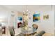 Open dining area with a glass table and wicker chairs, connected to the living room and kitchen at 7654 Comrow St # 202, Kissimmee, FL 34747