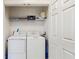 Bright laundry room featuring a washer, a dryer, and wire shelving at 7654 Comrow St # 202, Kissimmee, FL 34747