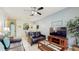 Open-concept living room with tile floors, a ceiling fan, and easy access to the kitchen and dining areas at 7654 Comrow St # 202, Kissimmee, FL 34747