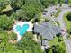 Aerial view of the community clubhouse and pool surrounded by trees and a small lake at 24 Lake Vista Way, Ormond Beach, FL 32174
