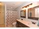 Bathroom featuring a double sink vanity with dark wood cabinets and framed mirrors at 24 Lake Vista Way, Ormond Beach, FL 32174