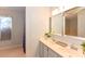 Bathroom featuring a double sink vanity with framed mirrors and a bright window with natural light at 24 Lake Vista Way, Ormond Beach, FL 32174