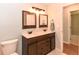 Bathroom featuring a double sink vanity with dark wood cabinets, framed mirrors and a standard toilet at 24 Lake Vista Way, Ormond Beach, FL 32174