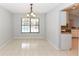 Bright dining room with tile flooring, view of the pool, and an adjacent pass-through to the kitchen at 24 Lake Vista Way, Ormond Beach, FL 32174