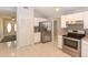 Kitchen with stainless steel appliances, white cabinets, and tile flooring, with a view of the front entrance at 24 Lake Vista Way, Ormond Beach, FL 32174