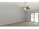 Large main bedroom with gray walls, neutral carpet, ceiling fan, and sliding doors to a patio at 24 Lake Vista Way, Ormond Beach, FL 32174
