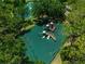 Aerial view of an outdoor playground with slides and climbing equipment surrounded by lush greenery at 24 Lake Vista Way, Ormond Beach, FL 32174