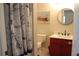 Nautical themed bathroom with a red vanity, a round mirror and a boat painting hanging above the toilet at 1048 Winding Water Way, Clermont, FL 34714