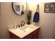 Stylish half bathroom with a modern sink, decorative mirror, and unique decor at 1048 Winding Water Way, Clermont, FL 34714