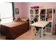 Comfortable bedroom features a single bed, white bookshelf, and a white desk, creating a functional space at 1048 Winding Water Way, Clermont, FL 34714