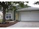 Charming one-story home with a well-maintained lawn and attached two-car garage at 1048 Winding Water Way, Clermont, FL 34714