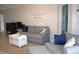 Living room with comfortable seating, neutral tones, and a decorative 'destinations' sign at 1048 Winding Water Way, Clermont, FL 34714