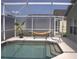 Inviting screened-in pool area with a hammock and tropical plant, perfect for outdoor relaxation and enjoyment at 1048 Winding Water Way, Clermont, FL 34714