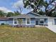 Charming blue home features a well-manicured front yard with a lovely garden and a fresh concrete driveway at 1121 W 9Th St, Lakeland, FL 33805