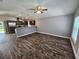 Open-concept living space with hardwood floors connecting the kitchen and a ceiling fan for comfort at 1121 W 9Th St, Lakeland, FL 33805