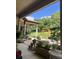 Charming patio with a brick surface, lush plants, and a wooden pergola overlooking a serene lawn at 16325 Magnolia Bluff Dr, Montverde, FL 34756