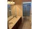 Bathroom featuring a double sink vanity, toilet and a tiled, glass-enclosed shower at 16325 Magnolia Bluff Dr, Montverde, FL 34756