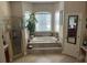 Well-lit bathroom with a step-up soaking tub, glass-enclosed shower, and neutral finishes at 16325 Magnolia Bluff Dr, Montverde, FL 34756