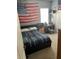 This bedroom features a bed with navy striped bedding and an American flag on the wall at 16325 Magnolia Bluff Dr, Montverde, FL 34756