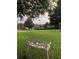 Scenic view of a well-manicured front lawn with a decorative bench under the shade of mature trees at 16325 Magnolia Bluff Dr, Montverde, FL 34756