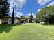 Inviting home featuring a manicured lawn, lush landscaping, and a stately entrance with white columns at 16325 Magnolia Bluff Dr, Montverde, FL 34756