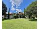 Inviting home featuring a manicured lawn, lush landscaping, and a stately entrance with white columns at 16325 Magnolia Bluff Dr, Montverde, FL 34756