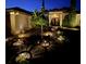 Beautifully landscaped front yard with lighting and attractive trees and plantings at twilight at 16325 Magnolia Bluff Dr, Montverde, FL 34756