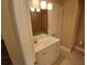 Bathroom with decorative lighting above the sink with tiled shower in the mirror's reflection at 2414 Willow Oak Dr, Edgewater, FL 32141