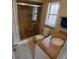 Bathroom featuring granite countertop vanity, window, and tiled shower with glass door at 2414 Willow Oak Dr, Edgewater, FL 32141