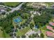 This community offers an aerial view of the tennis and basketball courts and community pool, surrounded by mature trees at 3939 Sunset Lake Dr, Lakeland, FL 33810