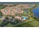 Community aerial view showcases pool, clubhouse, and surrounding residential neighborhood with lake, lush landscaping and winding roads at 3939 Sunset Lake Dr, Lakeland, FL 33810