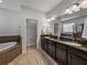 Ensuite bathroom with double vanity, soaking tub, and separate toilet room at 3939 Sunset Lake Dr, Lakeland, FL 33810