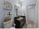 Bathroom featuring blue walls, granite counters, toilet, sink, decorative shelving, and wood-look flooring at 3939 Sunset Lake Dr, Lakeland, FL 33810